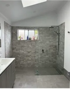 Renovated bathroom with a walk-in shower, black tapware and floor-to-ceiling tiles