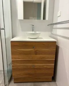 Bathroom vanity with a timber drawer unit, vessel basin and mirror cabinet